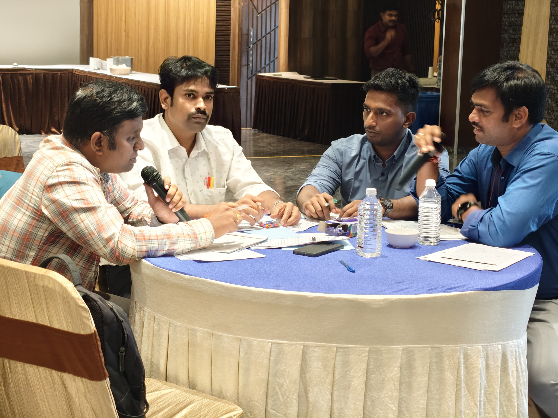 Professionals discussing ideas around a table during an interactive influence workshop